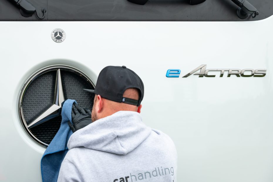 Ein Mitarbeiter putzt vor der Präsentation den Mercedes-Stern des neuen Fernverkehrs-Lkw «eActros 600» auf dem Autohof «Hamburg-Nordheide».