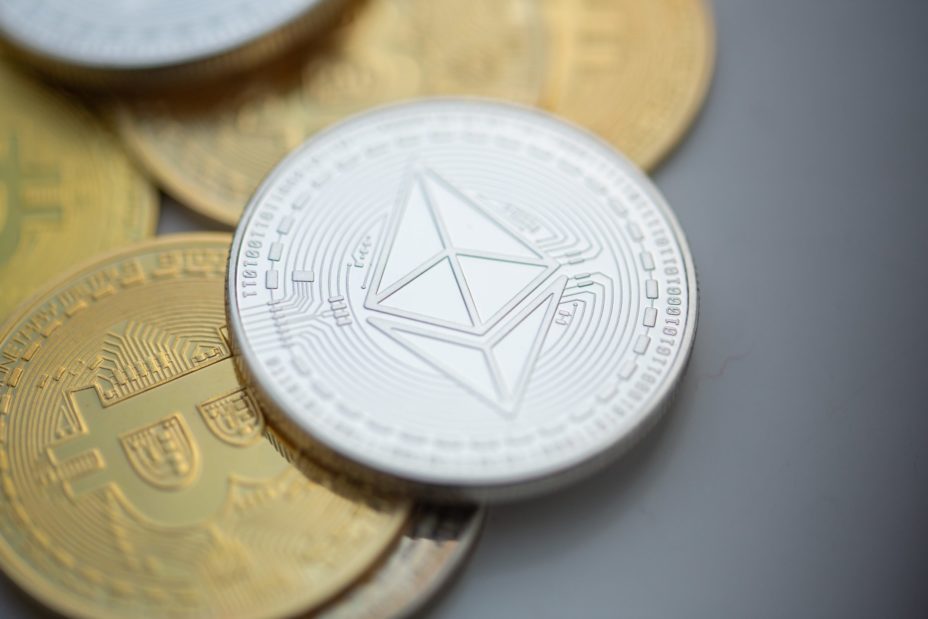 Eine Ethereum-Münze liegt auf Bitcoin Münzen