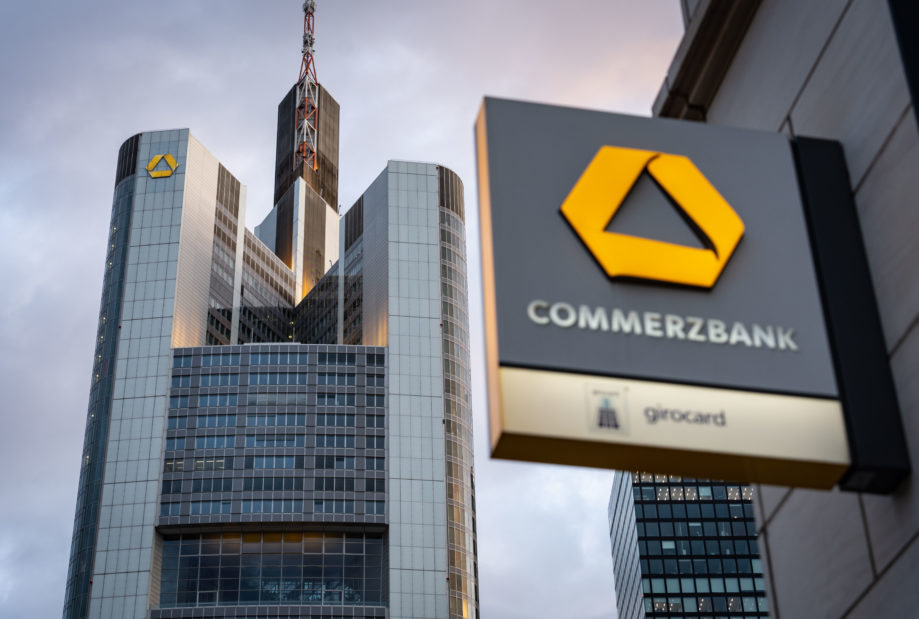 Das Logo des Commerzbank, an der Unicredit nun neun Prozent hält, ist an einer Filiale in Sichtweite der Zentrale der Commerzbank (l) angebracht.