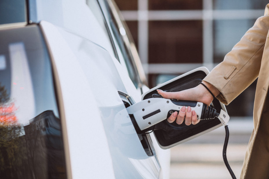 Eine Frau lädt ihr Elektroauto an einer Ladesäule auf
